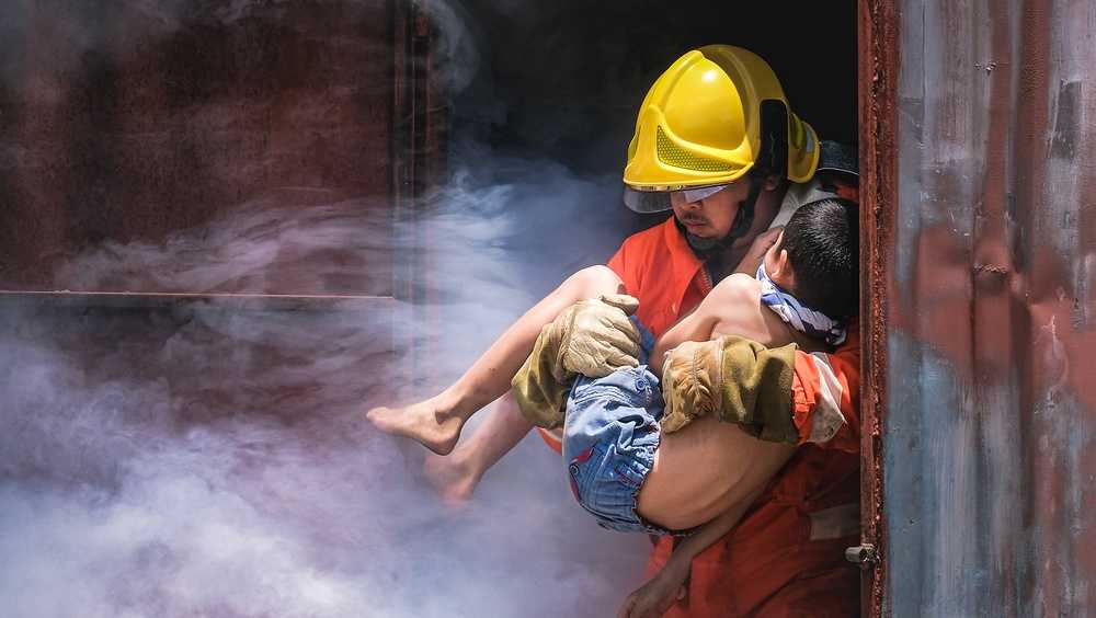 Прийти на помощь в любую. Спасение детей из пожара. Пожарный спасает ребенка. Пожарные на пожаре. Пожарные спасают детей от пожара.